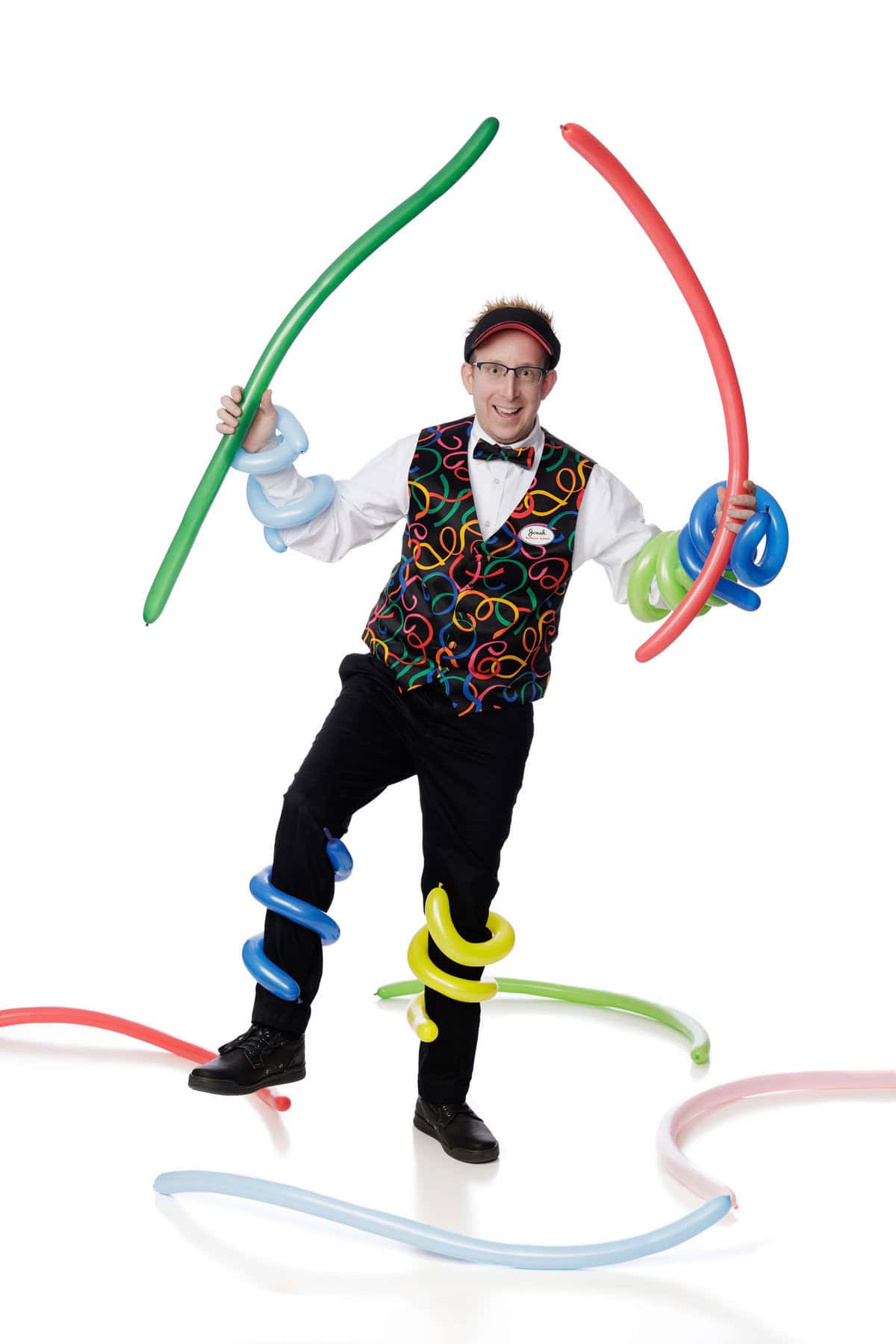 a man wearing a vest and glasses holding balloons